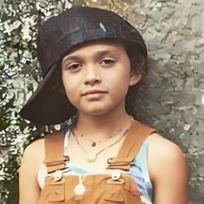 Childhood picture of Lola Lolani Momoa wearing a oversized cap.